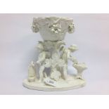 C19TH ENGLISH GEORGE MOORE FIGURE OF CHERUB BLACKSMITHS HOLDING A BOWL ON TREESTUMP OVER FLOWERS.