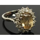 AN 18CT RING SET WITH A CENTRAL YELLOW TOPAZ + 16 SMALL DIAMONDS