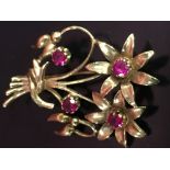 A GOLD BROOCH OF FLORAL DESIGN CLAW-SET WITH FOUR RUBIES (PROBABLY 18CT) HALLMARKED BUT INDISTINCT