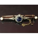 A SAPPHIRE AND DIAMOND BROOCH, THE CENTRAL OVAL SAPPHIRE SURROUNDED BY TWELVE DIAMONDS,