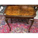 AN EDWARDIAN WALNUT FOLDING TOP CARD TABLE ON CABRIOLE LEGS