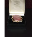 VICTORIAN PERIOD RECTANGULAR AGATE BROOCH IN A SCROLLED MOUNT,