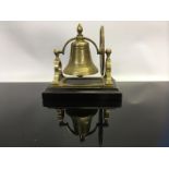 A BRASS 'DESK BELL' ON WOODEN BASE