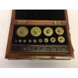 A CASED SET OF BRASS STANDARD APOTHECARIES FLAT WEIGHTS 10 TROY OZ NO. 2744 E.V.D.