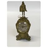 ANTIQUE CAST BRASS CASED DESK CLOCK DECORATED WITH A FINIAL OF AN ELIZABETHAN DRESSED FIGURE.