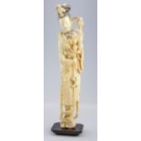 An early 20th century Chinese ivory figure, of a Ming Dynasty noblewoman holding peonies and wearing