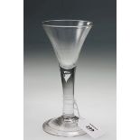 An early to mid 18th century trumpet wine glass, the plain tapering stem with tear drop inclusion