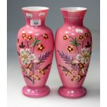 A pair of Edwardian pink satin glass vases, each of baluster form, hand decorated in enamels with