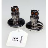 A pair of Edwardian silver owl menu holders, with glass bead eyes on circular bases, Chester 1901,