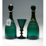 A small pair of early 19th century green glass decanters, each with flattened stopper, gilded with