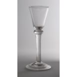 An 18th century flattened knop and plain stemmed wine glass, with small funnel bowl over a domed