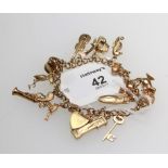 A gold charm bracelet, suspended with fourteen various charms including a blunderbuss and a