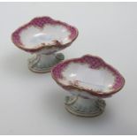 A pair of 19th century Meissen porcelain salts, of open shell form, the bowls decorated with figures