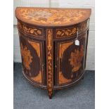 An early 19th century Dutch marquetry demi-lune cupboard, the top decorated with a flowering urn