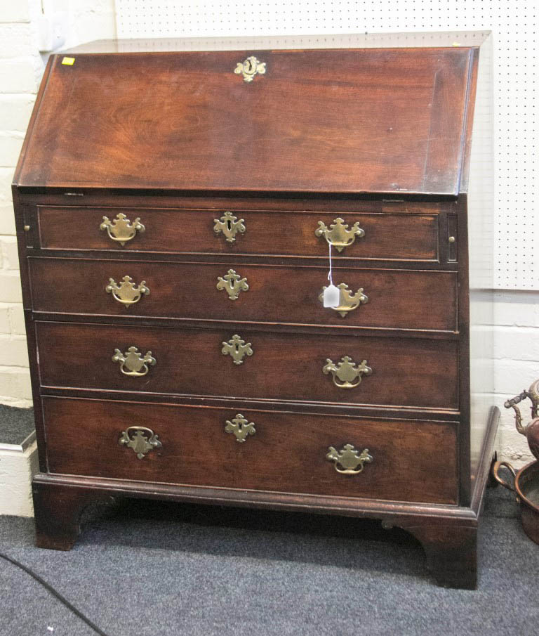 A George III mahogany fall front writing bureau, with simple fitted interior, over four long