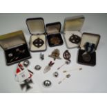 A collection of military and cap badges, buttons and other insignia, including Greek Sacred