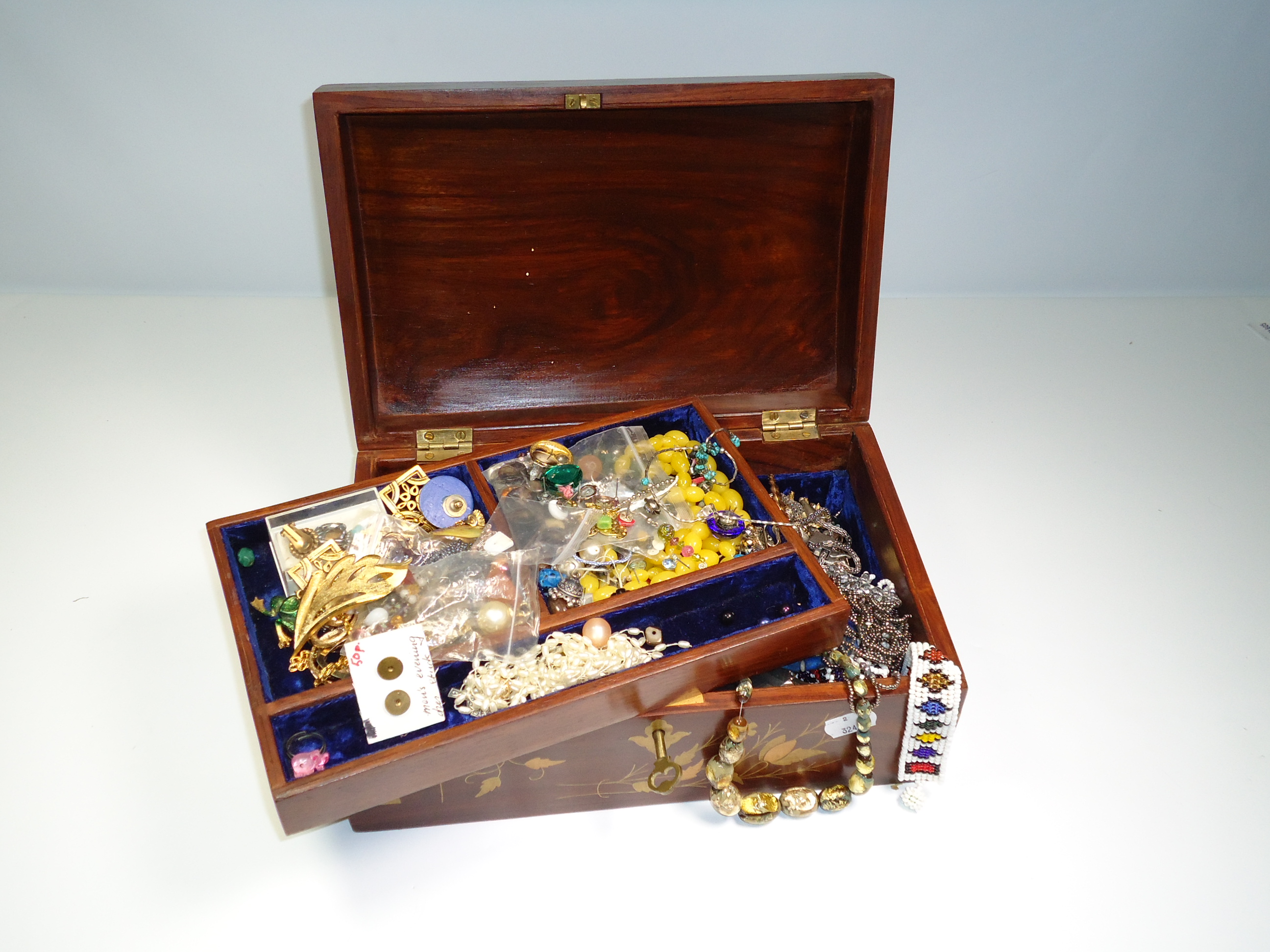 An Indian hardwood and brass bound jewellery box, containing a good quantity of costume and paste