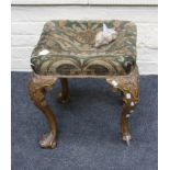 A 19th century, early 18th century style giltwood stool, the overstuffed seat on scrolled leaf