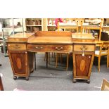 A George III mahogany twin pedestal satinwood strung mahogany sideboard, with inverted conical