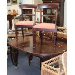 A Victorian mahogany extending oval dining table, with carved square supports, together with a