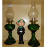 A pair of early 20th century green glass oil lamps, and an Avon 'Andy-Kap' novelty talcum powder