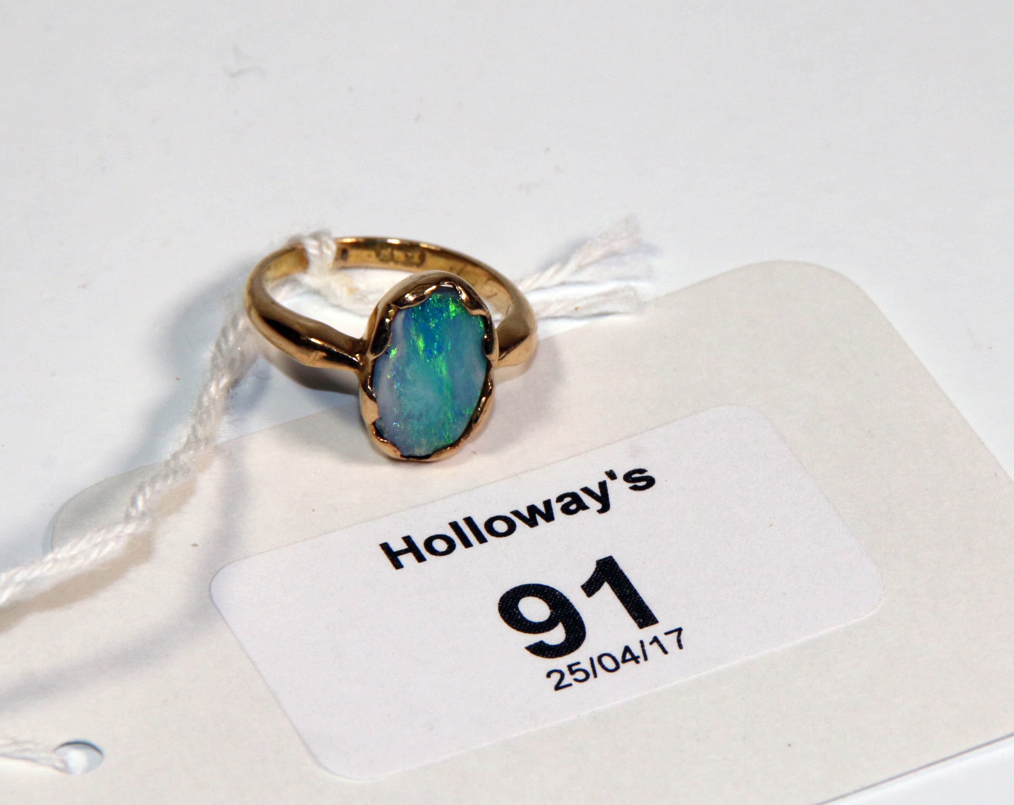 An 18ct gold dress ring, opal set with an oval shaped opal (doublet)
