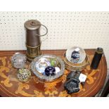 A collection of decorative glass paperweights, miner's lamp and cast iron eagle door knocker,