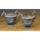 A pair of 19th century lead garden urns, each of campagna shape with leafy scrolled twin handles, on