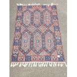 A 20th century Turkish rug, woven with lozenge pole medallions and stepped floral forms within a