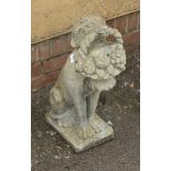 A reconstituted stone garden ornament, cast as a seated hound with fruit basket in mouth, 59cm