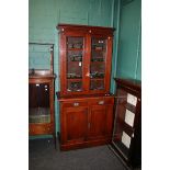 A late Victorian walnut bookcase cabinet, the moulded cornice over a pair of glazed doors, enclosing