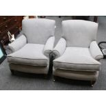 A pair of early 20th century drawing room armchairs, each having rolled back and arms, deep seat, on