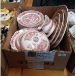 A red transfer decorated 'willow' pattern part dinner service