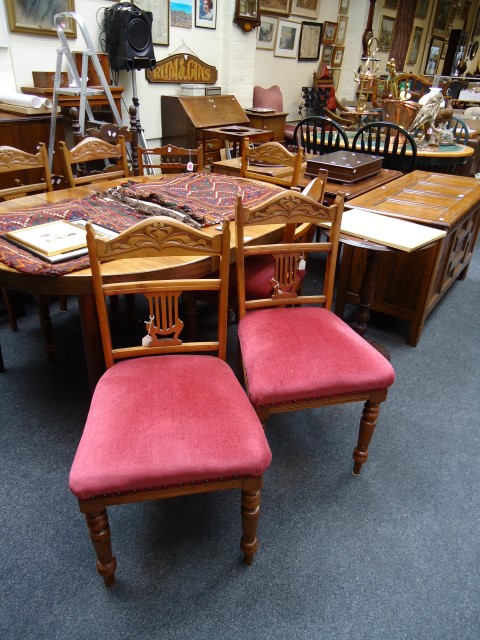 A set of six Edwardian walnut side chairs, with shaped and carved cresting rails over stuff-over