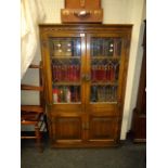 An Old Charm bookcase cabinet, with leaded glazed and linen-fold panel doors