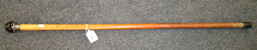 A late 19th century walking cane, the 'tiger's eye' pommel with silver collar over a tapering