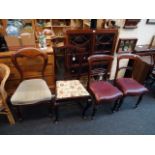 A pair of early Victorian mahogany dining chairs, with close studded burgundy hide upholstered seats