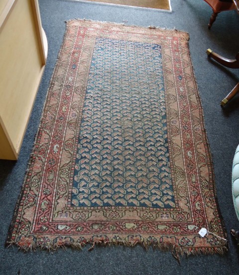 An early/mid 20th century Senneh rug, woven with central panel of stylised leaf form within a triple