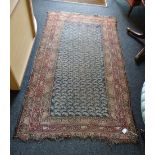 An early/mid 20th century Senneh rug, woven with central panel of stylised leaf form within a triple