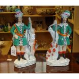 A pair of Staffordshire figures of bowmen, one with deer, the other with hunting dog