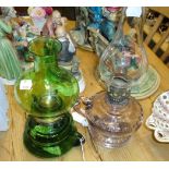 An Edwardian green glass chamber paraffin lamp, together with another having clear chimney, pale