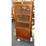 A 1930s walnut freestanding corner cupboard, with single glazed door, raised on cabriole supports