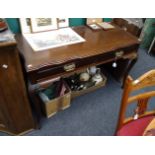 An Edwardian mahogany serving table, the rectangular serpentine top with reeded edge over two frieze