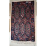 A 20th century Turkish rug, woven with lozenge pole medallions and stepped floral forms within a