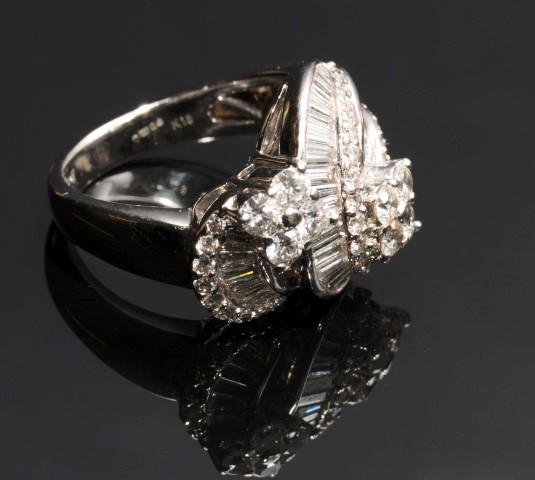 A diamond set cross-over dress ring, with two scrolling bands of graduated baguette diamonds