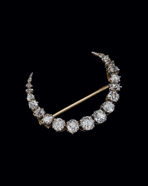 A late Victorian diamond crescent brooch, the graduated mixed old cut and cushion cut diamonds in