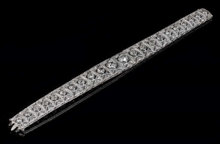 An Art Deco diamond bracelet, the tapering panels set with graduated old brilliant cut diamonds in