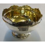 A rosebowl, with arched rim, above hand, stepped circular skirt foot, gilt interior, Chester 1924,