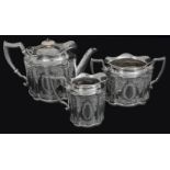 A Victorian three piece silver teaset, of panelled oval form, foliate engraved to body, with