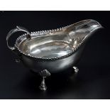 A George III Newcastle sauce boat, with punch bead border, flying scroll handle and three shell